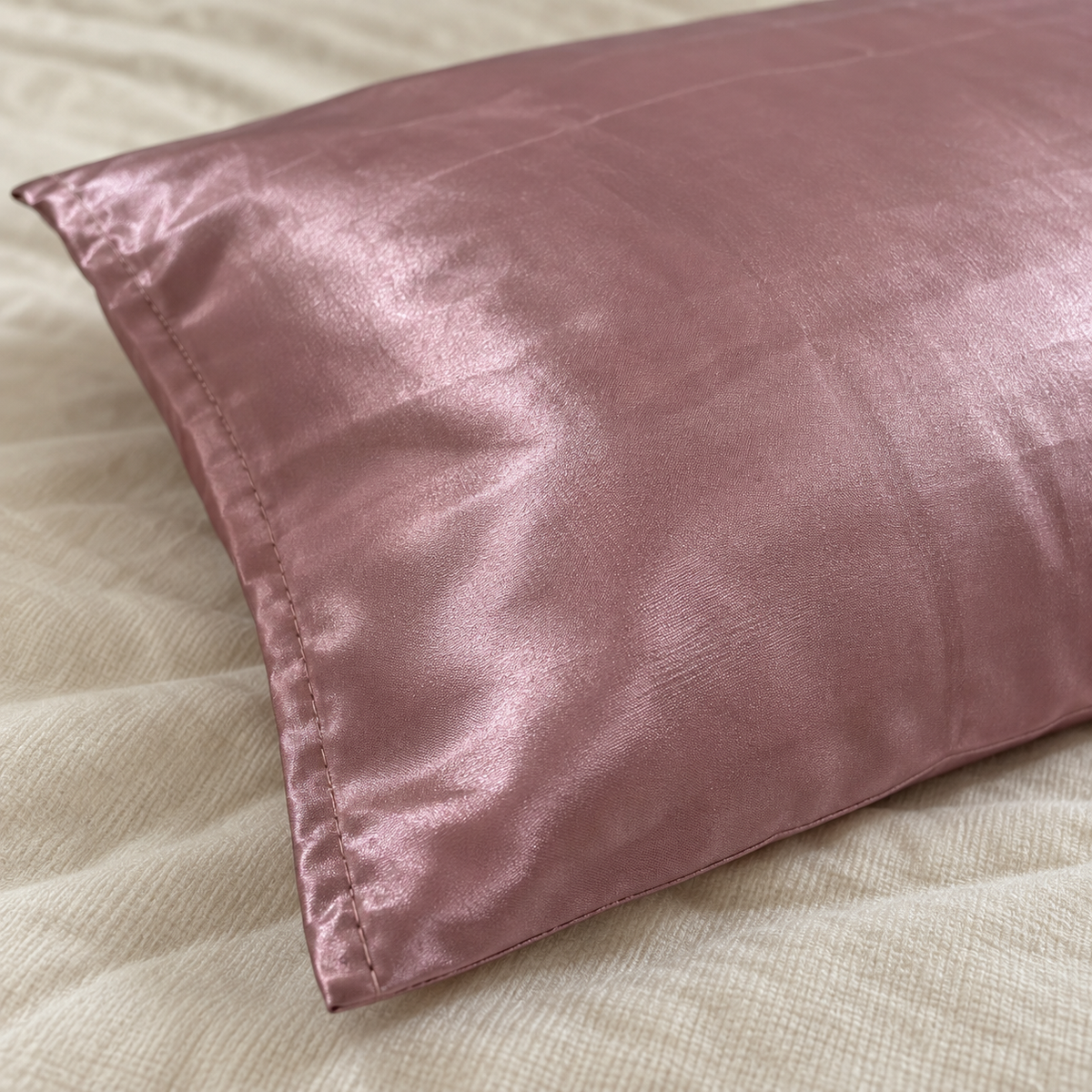 Taie d’oreiller en satin rose poudré Curlizea sur drap
